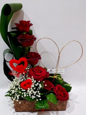 A special composition in a rectangular basket with red roses.