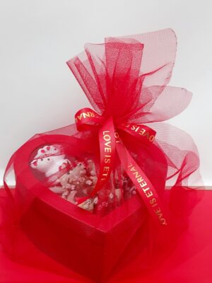 Εντυπωσιακή κόκκινη  κραφτ καρδιά με διάφανο σκέπασμα και ορχιδέες συμπίντιουμ λευκές.Σοκολάτα λάκτα,μικρά αρκουδάκια και καρδούλα