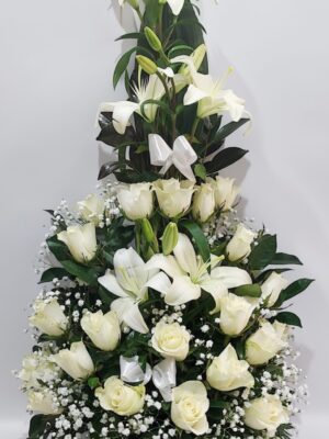 Eντυπωσιακή σύνθεση για μνημόσυνο με λευκά τριαντάφυλλα και λευκά λίλιουμ.΄Διαστάσεις 60 εκ. ύψος και 35 εκ.πλάτος