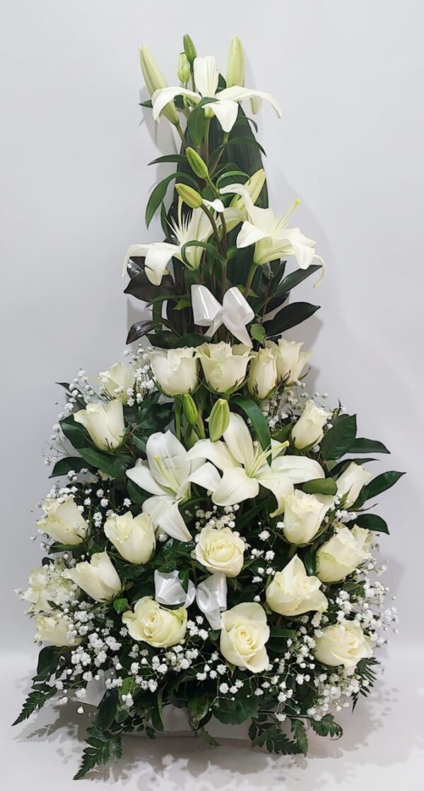 Eντυπωσιακή σύνθεση για μνημόσυνο με λευκά τριαντάφυλλα και λευκά λίλιουμ.΄Διαστάσεις 60 εκ. ύψος και 35 εκ.πλάτος